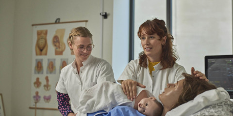 To jordemoderstuderende øver sig i Praksis- og Innovationshuset på en fødestue med to fantomdukker- en mor og hendes baby