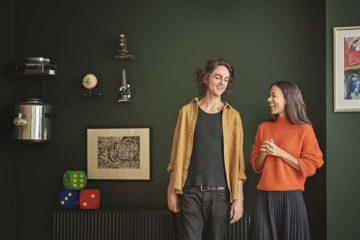 To pædagogstuderende foran en grøn væg