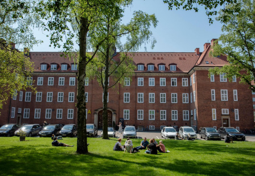 En gruppe af studerende slænger sig i en cirkel ved indgangen til Københavns Professionshøjskoles på Tagensvej 18