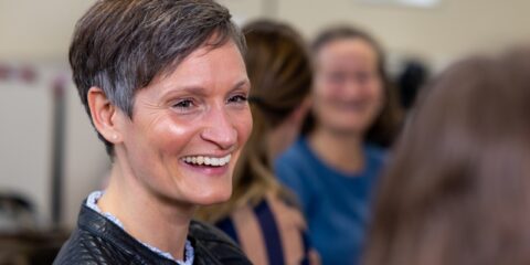 Smilende kvinde der deltager i diplom i ledelse