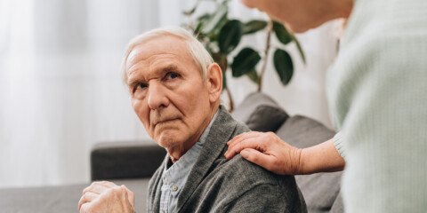 Ældre mand med stok får en venskabelig hånd lagt på skulderen