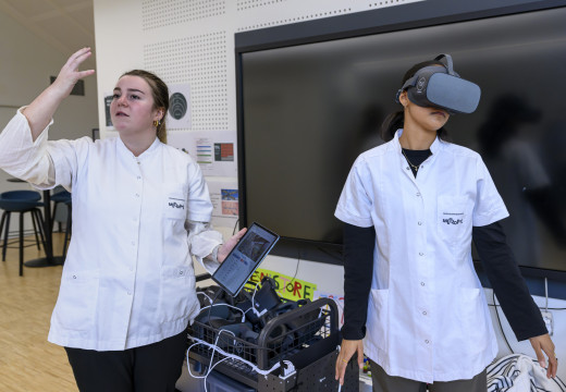 En studerende med virtual reality briller og én der forklarer