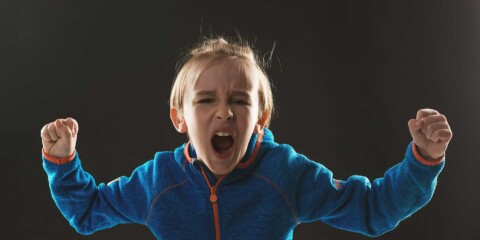 Vred dreng, der råber og knytter hænderne